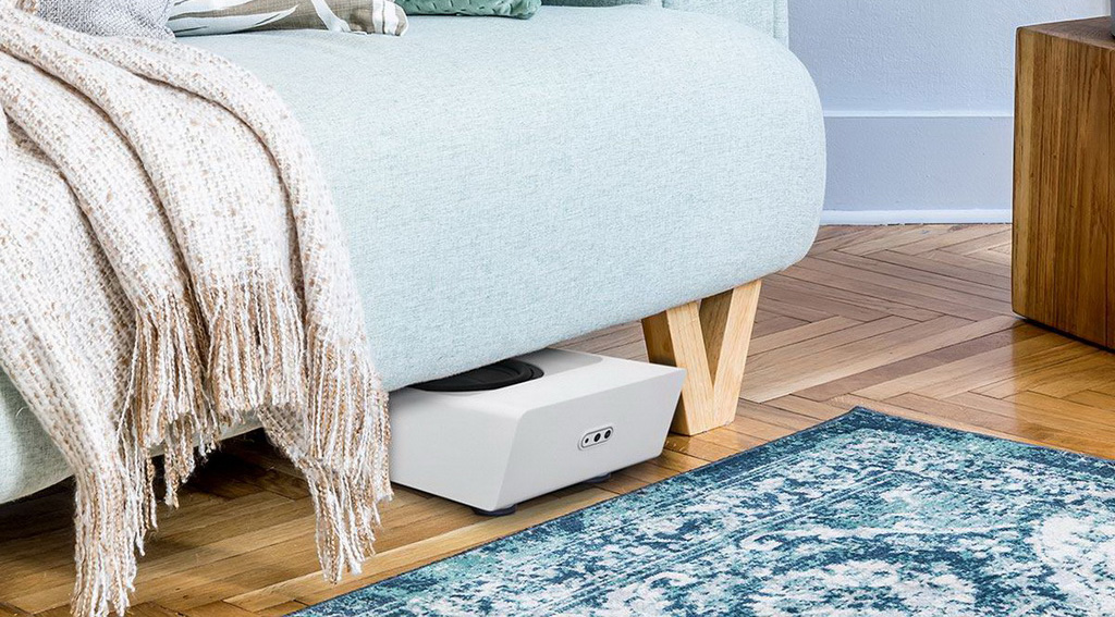Bluesound Pulse Sub Plus белого цвета под диваном в гостиной &mdash; компактные размеры позволяют скрытую установку